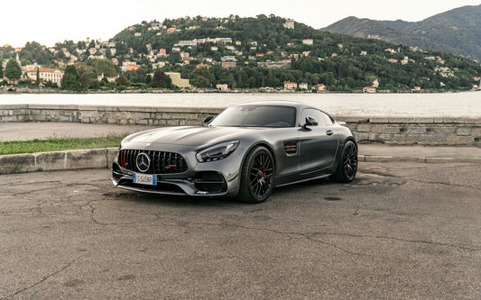 Gray mercedes-benz sports car parked by a lake